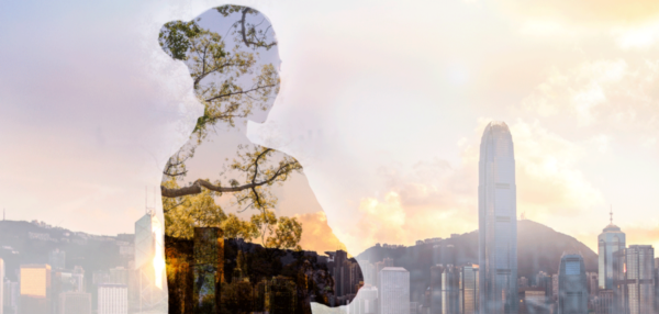 Double exposure image of woman with cityscape and trees.