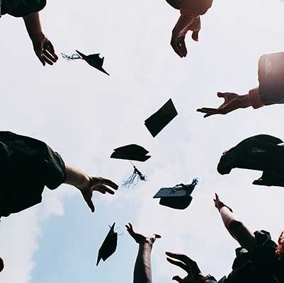 Group of graduates throwing their caps in the air