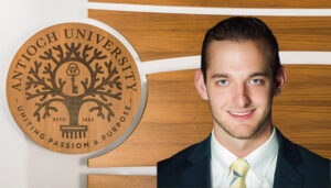 Portrait of Brett Jones in front of the Antioch University Seal